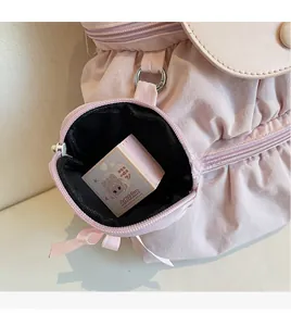 Detail van roze nylon rugzak met een afneembare mini ronde ritszak voor opbergruimte