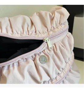 Detailopname van roze nylon rugzakstof met soepele metalen rits en magnetische sluiting