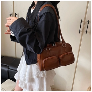 Close-up of brown faux leather shoulder bag featuring dual front zipper pockets