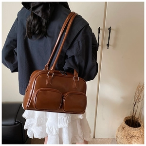 Detailed back view of vintage brown leather shoulder bag with two front pockets