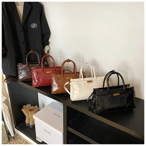 Detailed display of vintage briefcase style handbags in five colors with metal buckles
