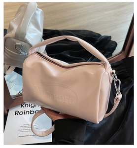 Detail showing the embossed NORONORO logo on pink and beige glossy leather handbags