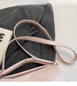 Macro detail of soft pink oil wax leather handbag with sleek zipper and thin shoulder strap