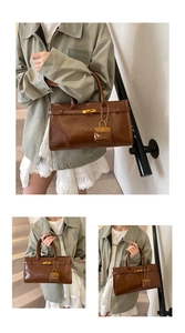 Detail of vintage brown patent leather handbag with golden twist lock and top handle