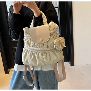 Close-up of pleated nylon backpack with heart-shaped coin purse and single buckle closure