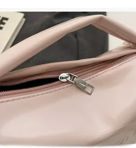Detail of pink vintage oil wax leather bag featuring smooth silver metal zipper and stitching