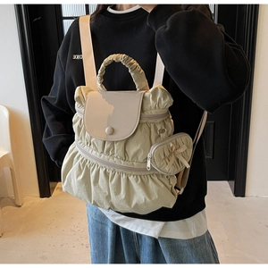 Detail view of beige pleated nylon backpack with matching bow wallet and soft handle