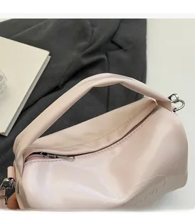 Detailed close-up of pink vintage oil wax leather handbag with embossed letters and metal zipper