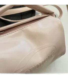 Detail of light pink faux leather bag showing soft texture and embossed nororo logo