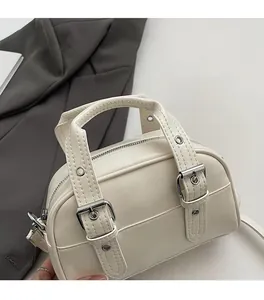 Gros plan du sac à main Boston blanc crème avec poignée et boucles détaillées
