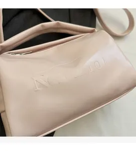 Detailed close-up of the Noronoro embossed logo on a pink vintage oil wax leather bag