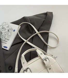 Détails du sac à main crème avec boucles métalliques doubles et fine bandoulière