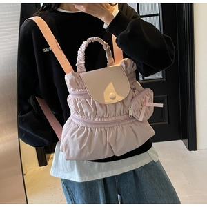 Detail of light pink pleated nylon backpack with matching small bow charm bag