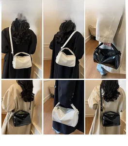 Detail showing versatile black and white glossy leather hobo bags with detachable straps