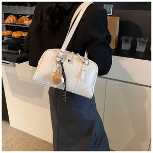 Detailed side view of white vintage patent leather Boston bag with decorative charms