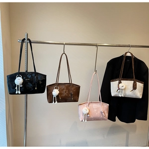 Detail of four vintage large capacity tote bags with plush pendants on a hanger