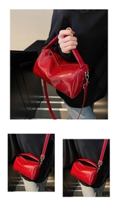Detail of red glossy cylindrical bag with embossed logo and silver metal buckles