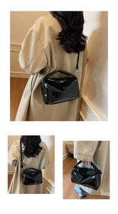 Detail showing shiny black patent leather surface with embossed Norononno logo on a bag
