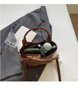 Detailansicht der braunen Beuteltasche mit Platz für Handy, Geldbörse und Regenschirm