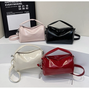 Group shot of glossy cylinder bags in pink, black, cream, and red on display