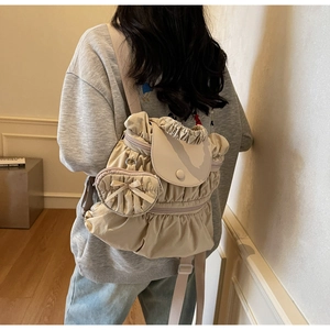 Detail showing pleated nylon backpack with a cute heart-shaped charm and round buckle