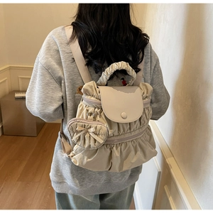 Detail of light beige pleated backpack with heart coin purse on vintage interior background