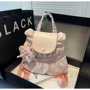 Detail view of pink ruffled nylon backpack with matching mini bow coin purse accessory