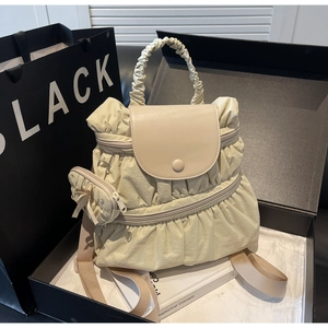 Detail of cream pleated nylon backpack with matching mini round zip pouch charm