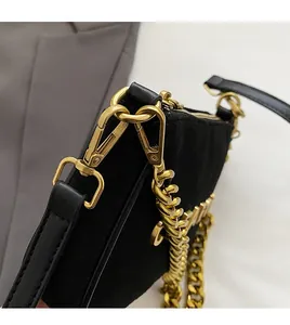 Detail of matte black leather bag with vintage gold chain and detachable spring hook