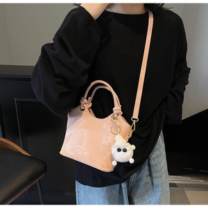 Detail der rosa Beuteltasche mit Marmorstruktur und süßem Plüschtier-Anhänger