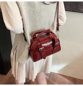 Détail du mini sac Boston rouge foncé rétro avec boucles argentées et fini brillant