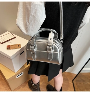 Détail d'un mini sac Boston argenté avec texture en cuir et doubles bandoulières