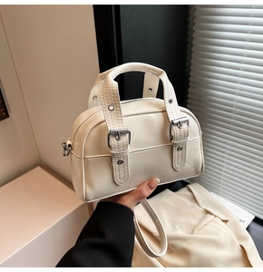 Détails d'un mini sac boston beige avec boucles argentées et texture cuir naturel