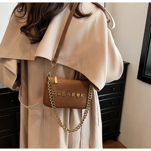 Detail of brown faux suede shoulder bag with gold chain and CLEAR metal logo