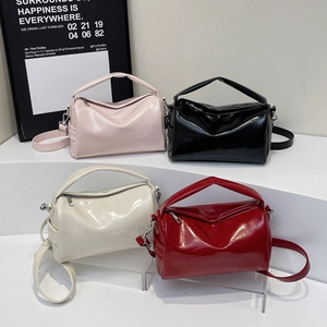 Glossy faux leather cylinder Boston bag in four colors on a minimalist display