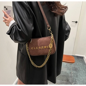 Detail view of brown matte small square bag with gold chain and CLEAR K metal logo