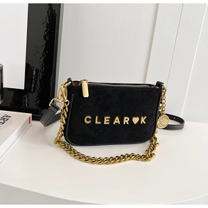 Close-up of matte black suede crossbody bag featuring gold hardware and chain strap