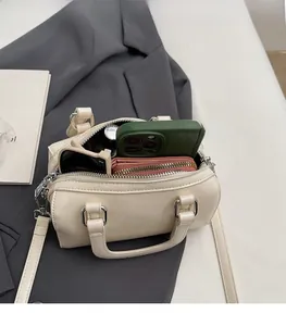Vue détaillée de l'intérieur spacieux d'un sac Boston blanc cassé avec des objets du quotidien