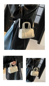 Détail du sac Boston blanc cassé minimaliste avec doubles poignées et bandoulière réglable