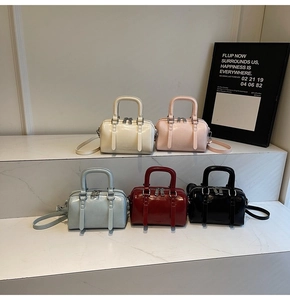 Vue détaillée des sacs Boston en cinq couleurs brillantes sur un présentoir boutique