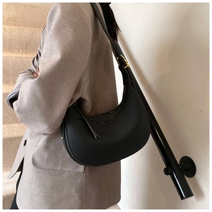 Dettaglio della borsa a mezzaluna in pelle nera martellata con hardware oro antico