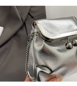 Detailed macro view of the silver metallic clasp and pebble texture on the mini shoulder bag
