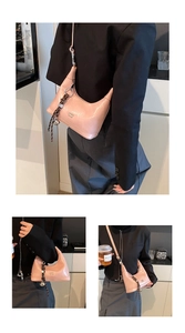Detail of pink glossy leather crescent bag with decorative woven strap and metal rings