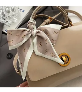 Detailed close-up of a vintage messenger tote with silk scarf and metal swivel lock