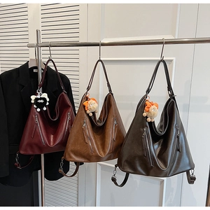 Close-up of vintage PU leather tote bags in burgundy, caramel, and dark brown colors