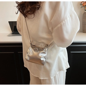Close-up of a silver metallic crossbody bag featuring retro clasp and elegant chain strap