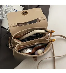 Macro view of beige leather bag interior featuring double main compartments and zippers
