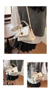 Detail of white leather shoulder bag featuring vintage gold twist lock and floral silk scarf