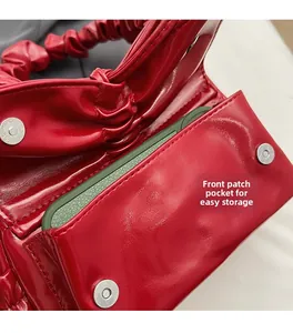 Close-up of red pleated handbag featuring a front patch pocket for easy phone storage