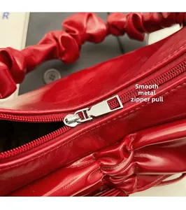 Detail of red leather bag with smooth silver metal zipper and stylish ruched texture